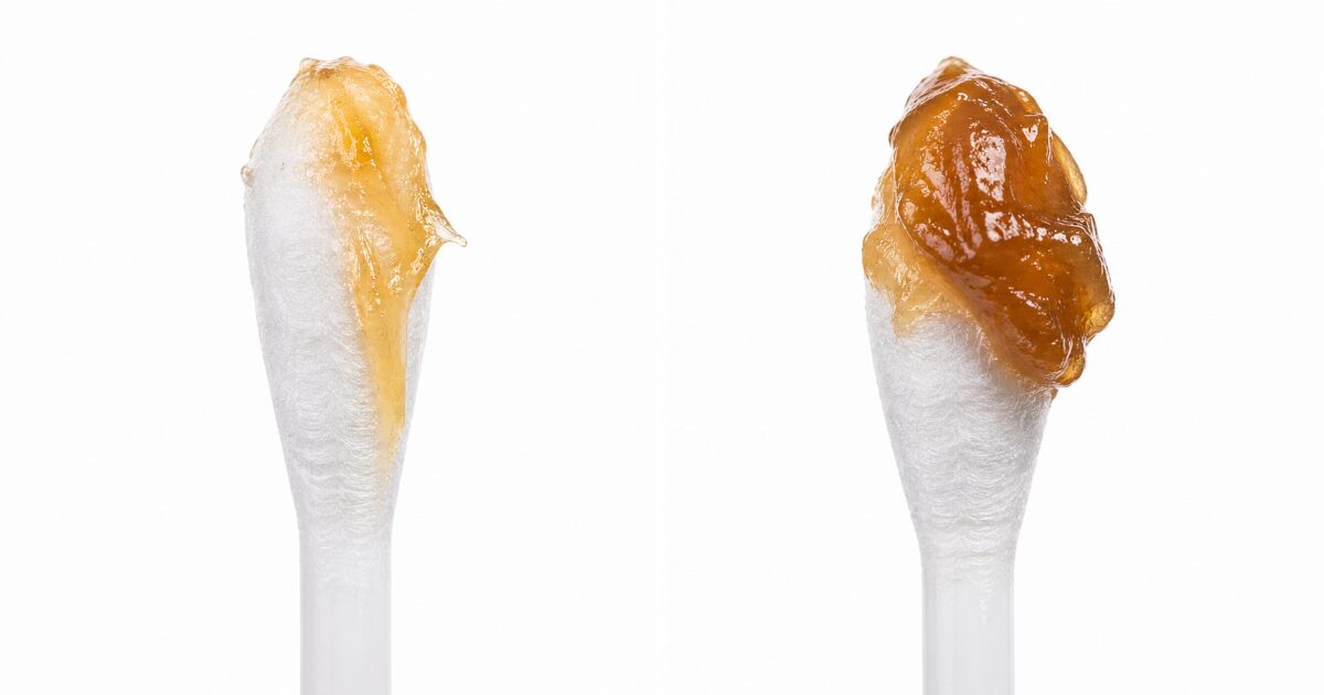 綿棒の先に薄く伸びる湿性耳垢と、塊状に付く湿性耳垢の比較画像